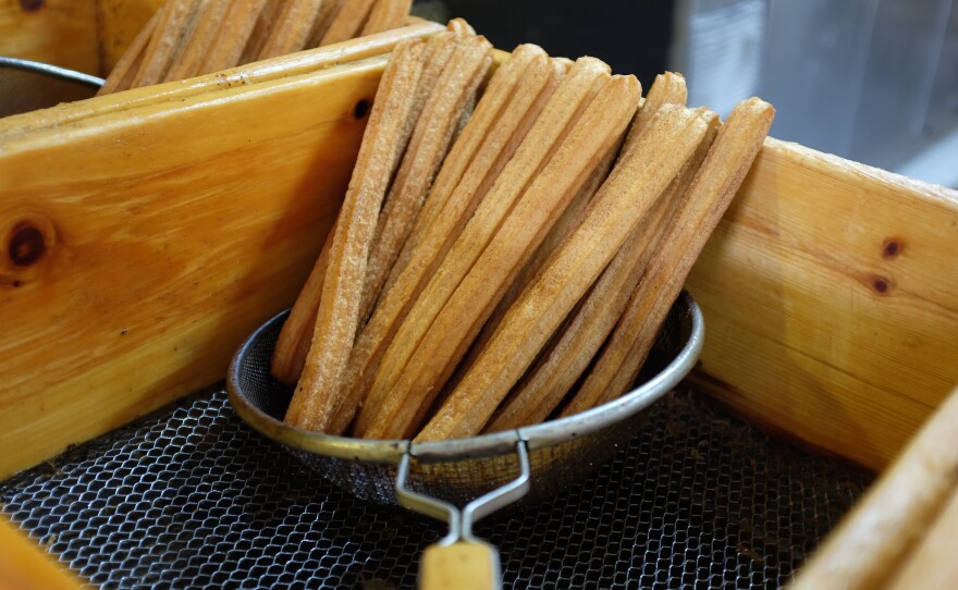Fresh churros are drained before they are stacked on trays for vendors to pick up.