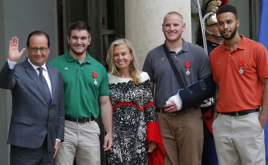 From the left, French President François Hollande, U.S. National Guardsman from Roseburg, Oregon, Alek Skarlatos, U.S. Ambassador to France Jane D. Hartley, U.S. Airman Spencer Stone and Anthony Sadler, a senior at Sacramento University in California, pose for photographers as they leave the Elysee Palace in Paris, France.