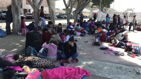 A group of people seeking asylum in the U.S. wait near the border in Tijuana, April 25, 2018. 
