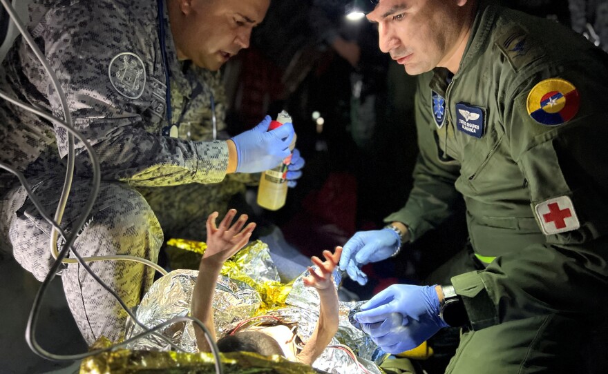 Soldiers of the Colombian Air Force give medical attention inside a plane to the children who survived a Cessna 206 plane crash in the thick jungle, while they are transferred to Bogotá by air in San José del Guaviare, Colombia, June 9.