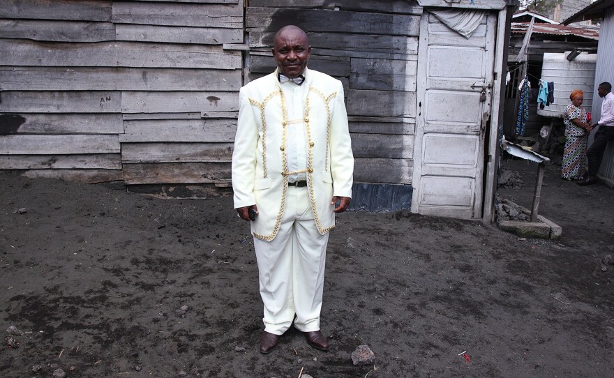 Theobold Kawa, a 55-year-old pastor, stands outside of AEPL Makedonia church in Goma. He  bought his suit in Uganda. "I'm dressing up like this because of the Glory of God," he says. "A servant of God shouldn't look dirty."