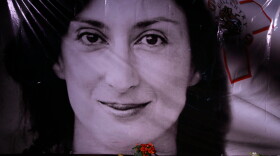 Flowers and a candle lie in front of a portrait of slain investigative journalist Daphne Caruana Galizia during a vigil outside the law courts in Valletta, Malta, Oct. 16, 2018.