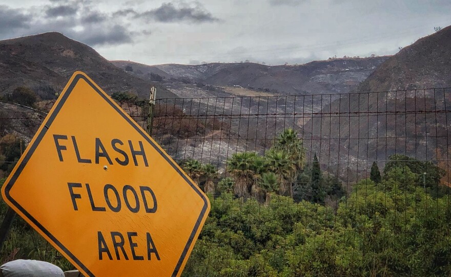 A flash flood area sign is posted as residents evacuate from several fire-ravaged communities in Santa Barbara, Calif.