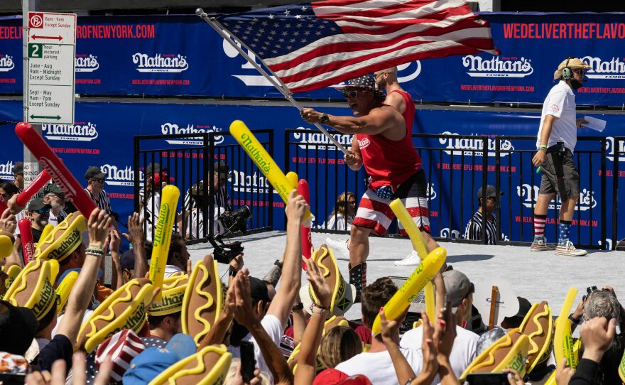 A performer waves an American flag during the 2022 Nathan's Famous Fourth of July hot dog eating contest.