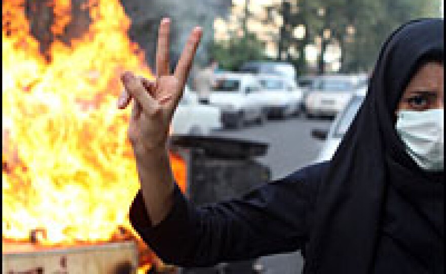 A female protester in Tehran makes a V sign for victory July 9. Journalist Roger Cohen stayed in Tehran, even after the Iranian government revoked all foreign press passes.