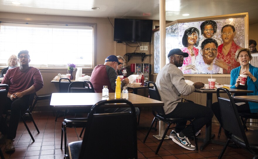 Democratic presidential candidate Sen. Elizabeth Warren, D-Mass., eats lunch with musician Benny Starr at Bertha's Kitchen on Friday in North Charleston, S.C.