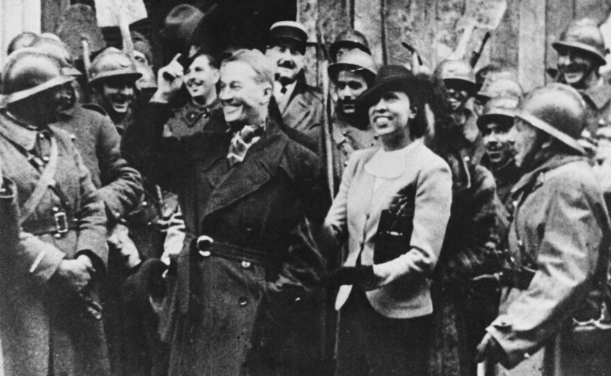 Entertainers Maurice Chevalier and Josephine Baker are cheered by officers and men of the French Army as they arrive at the front during World War II, circa 1940.