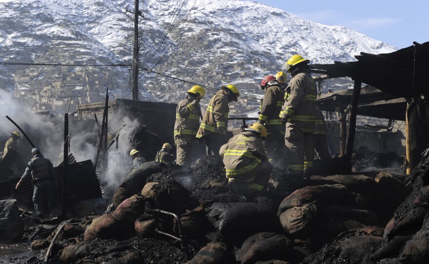 Kabul firefighters dowse a coal market fire in 2011.