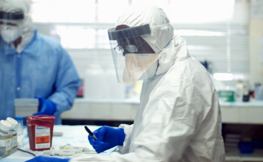 Augustine Goba (right) heads the laboratory at Kenema Government Hospital in Sierra Leone. He and colleagues analyzed the viral genetics in blood samples from 78 Ebola patients early in the epidemic.