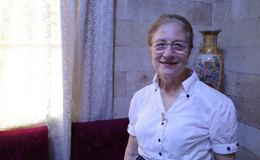 Denise Khoury, standing inside the Church of the Sacred Heart of Jesus in Latakia, says she checked on her mother's home in northern Syria after the war and found it occupied by foreign fighters.