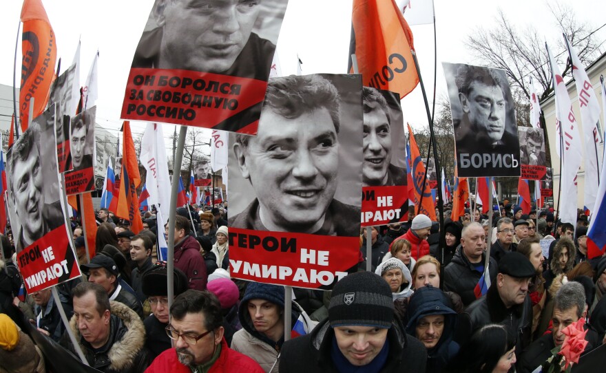 Russians hold flags and posters during a march to commemorate Nemtsov.