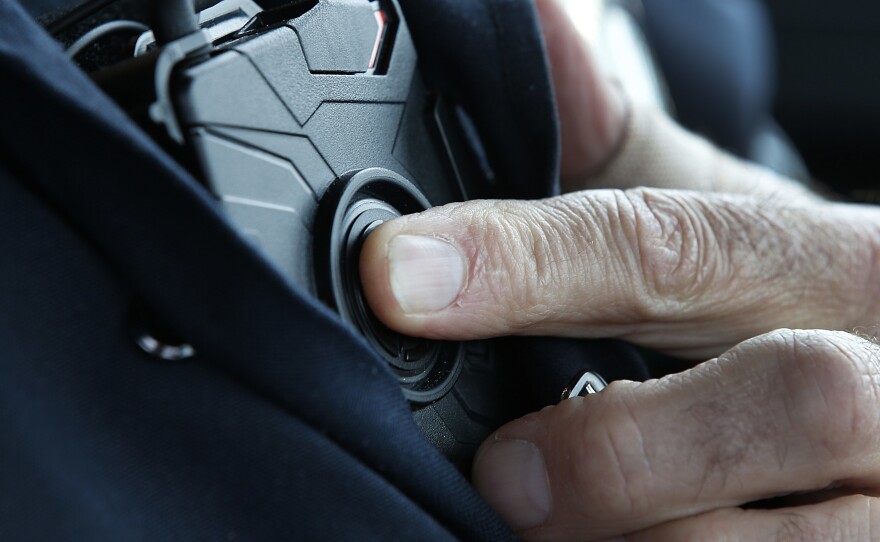 A patrol officer in West Valley City, Utah, starts a body camera recording by pressing a button on his chest in March 2015. The West Valley City Police Department issued 190 Axon Flex body cameras for all its sworn officers to wear.