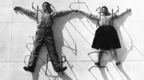 Charles and Ray Eames “pinned” by chair bases, 1947.