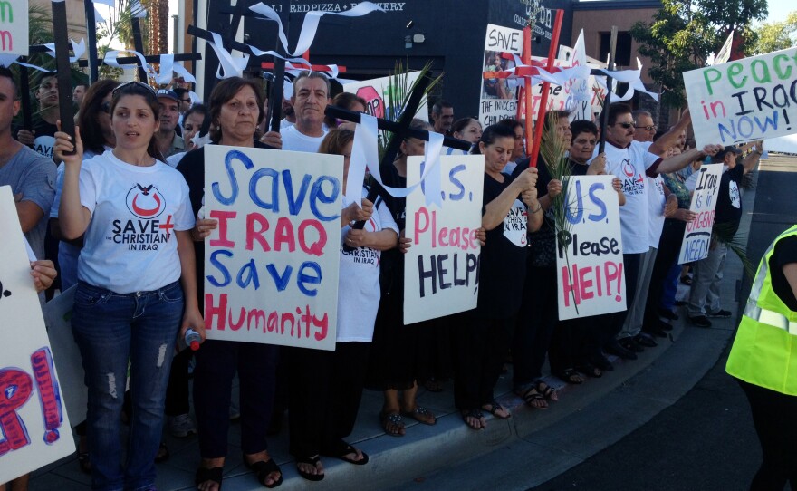 Marchers hold up crosses and signs calling for asylum for Iraqi Christians, on the corner of Magnolia Avenue and Main Street in El Cajon, Aug. 19, 2014.