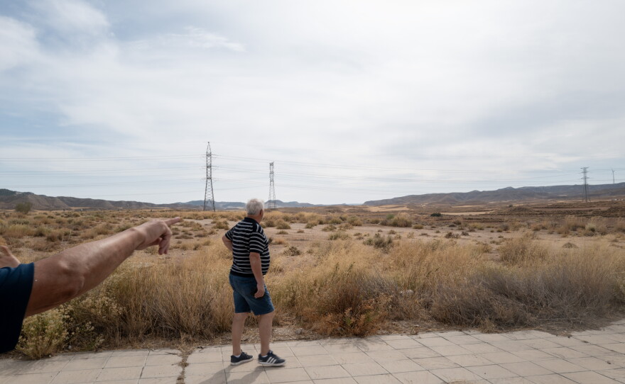 Residents point to an area that is to be developed into a data center complex in Botorrita, Spain, on Sept. 28. Residents say the planned complex comes to within 80 meters of the garden wall of a family living at the village edge.