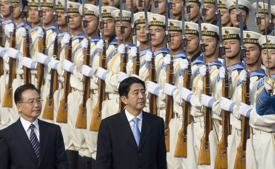 Chinese Premier Wen Jiabao (left), walks with Japanese Prime Minister Shinzo Abe as they inspect a guard of honor during the welcome ceremony held outside the Great Hall of the People in Beijing, Oct. 8, 2006.