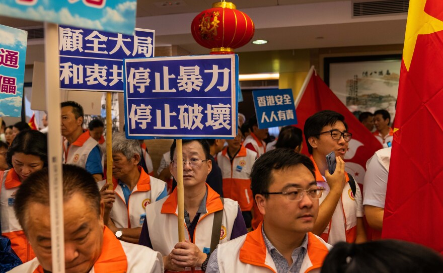 Pro-Beijing demonstrators gather at the Hong Kong Federation of Fujian Associations to show support for the Hong Kong police on Aug. 10.