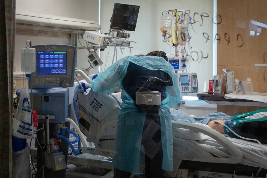 A registered nurse wearing protective equipment treats a COVID-19 patient in Scripps Mercy Hospital Chula Vista's intensive care unit in June 2020. Ten beds in the hospital’s 12-bed ICU were filled with coronavirus patients.