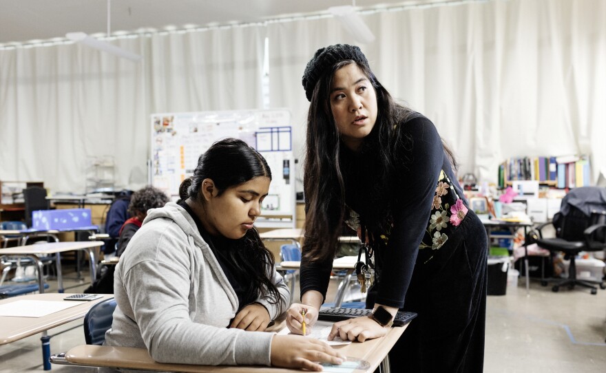 Mary Acebu, a special education teacher at Riverview Middle School in Bay Point, Calif., works with a student during a math lesson. She says using AI to help with the paperwork part of her job allows her to spend more time interacting with her students in a meaningful way.