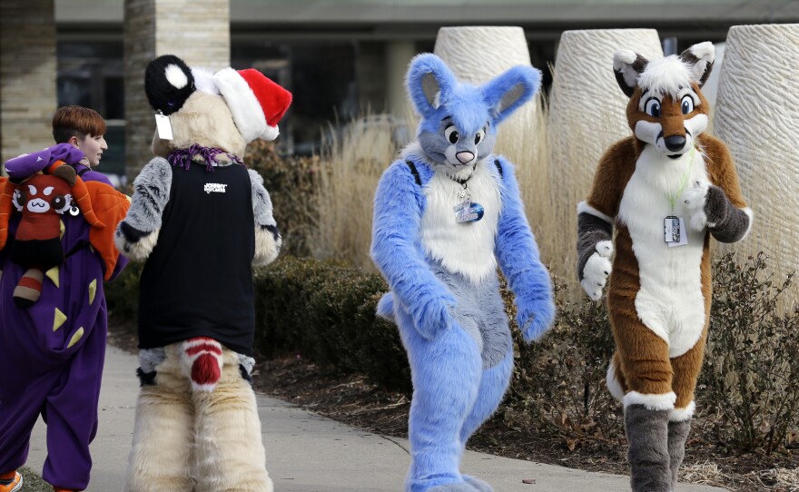 Frederic Cesbron, right and Maxim Durand, walk on the street outside the Hyatt Regency O'Hare hotel i Rosemont, Ill., on Sunday.  Thousands of people were evacuated earlier after a chlorine gas leak at the hotel, which is hosting the 2014 Midwest FurFest convention.