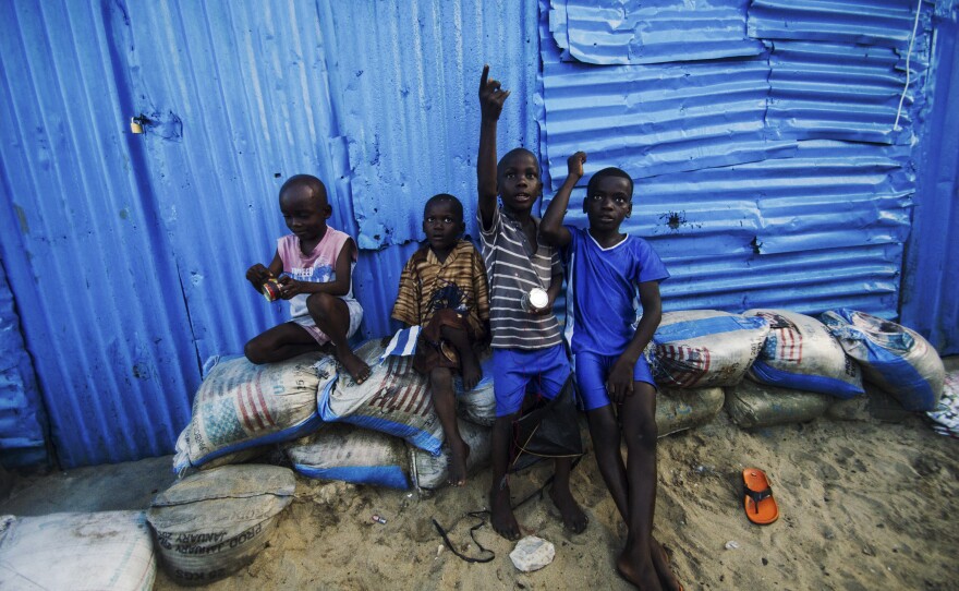 Kids in West Point hold tin cans wrapped with string for the kites they're flying.