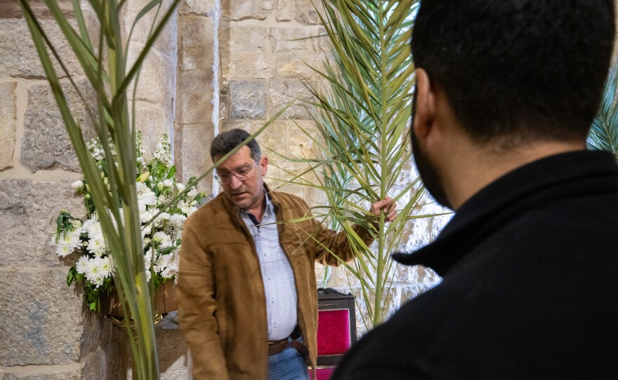 Naim Rouhaim, whose brother is the parish priest, helps to set up palms at St. Maron church, the evening before Palm Sunday.