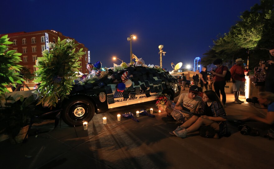 People attend a vigil outside Dallas police headquarters on Thursday.