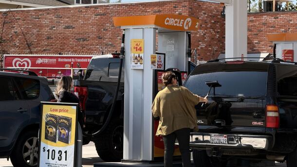 A woman cleans her windshield as another woman pumps gas at a Circle K gas station in Chula Vista, March 5, 2026.