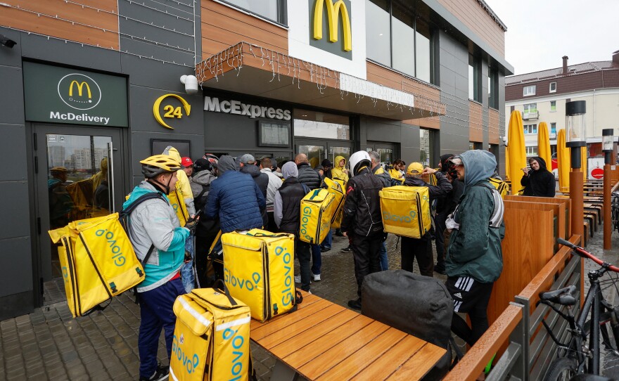 Glovo food delivery couriers wait to pick up orders outside a McDonald's restaurant after the chain reopened in Kyiv on Tuesday.