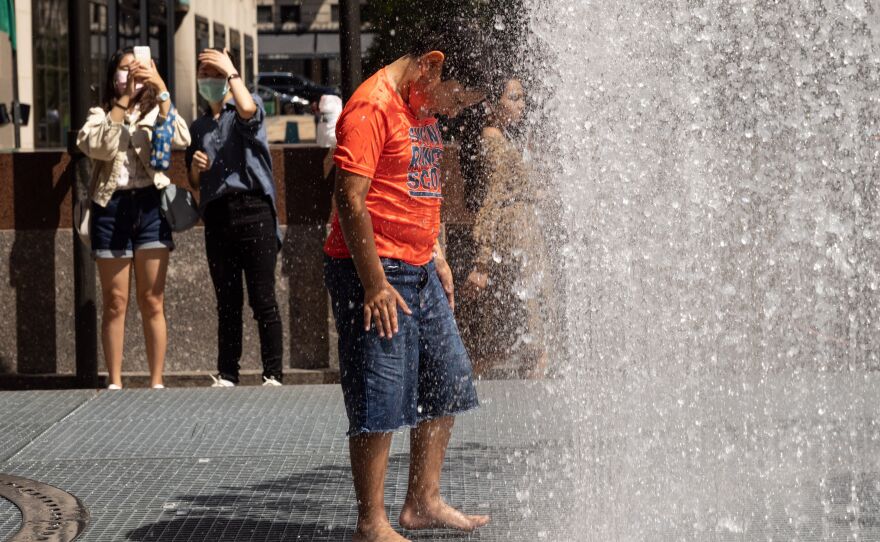 People play in artist Jeppe Hein's water-based sculpture titled <em>Changing Spaces</em> at Rockefeller Center Plaza in New York City on Tuesday.