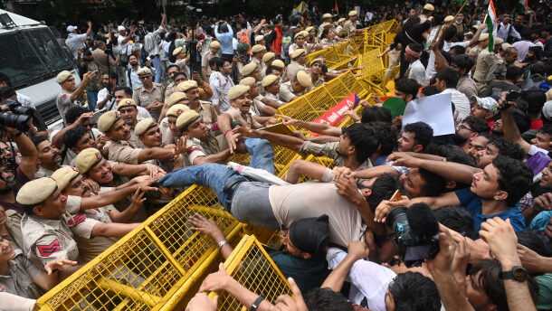 Supporters of the Cockroach Janta Party scuffle with police as they attempt to march to India's Parliament, demanding the resignation of the education minister, in New Delhi, Monday.