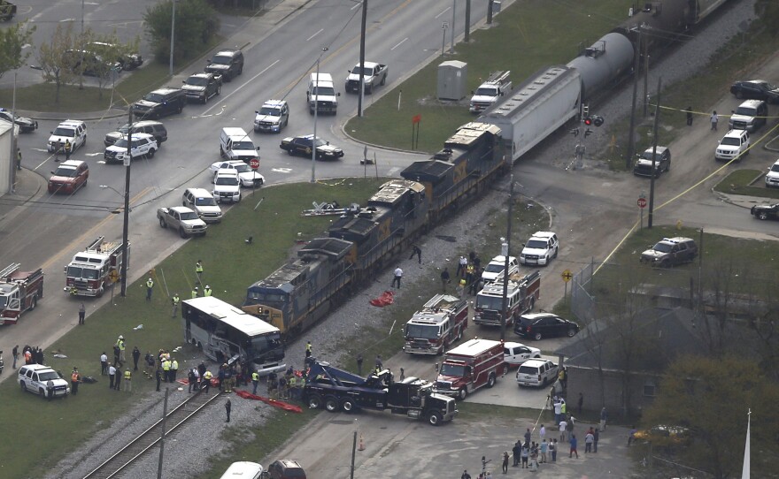 Emergency crews work on the scene where a train hit a charter bus in Biloxi, Miss., Tuesday. The National Transportation Safety Board says the freight train was traveling about 19 mph at the time of the crash.