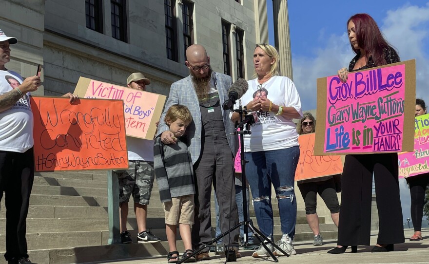 Carolyn Miller (center right) speaks at a news conference called by friends and family of Tennessee death row inmate Gary Sutton on Oct. 6, outside the Tennessee State Capitol in Nashville. Rev. Jeff Hood stands next to Miller while hugging his son.
