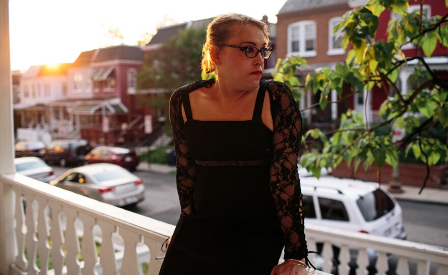 Kiera Atkins smokes on the porch of a transitional group home for transgender adults who are trying to get on their feet.