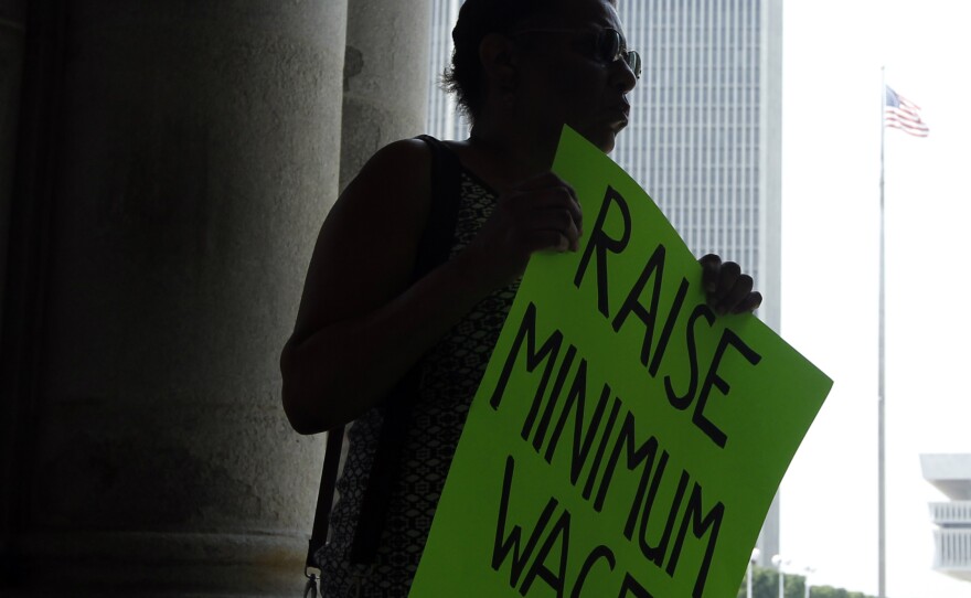 Wendy Brown of Schenectady, N.Y., holds a sign before an Occupy Albany rally pushing for a raise in New York's minimum wage on May 29, 2012.