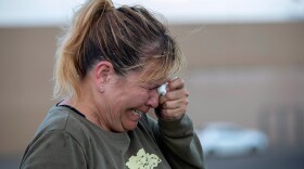 Edie Hallberg cries while speaking to police outside a Walmart store where a shooting occurred earlier in the day as she looks for her missing mother Angie Englisbee, who was in the store during the attack in El Paso, Texas, Aug. 3, 2019. 