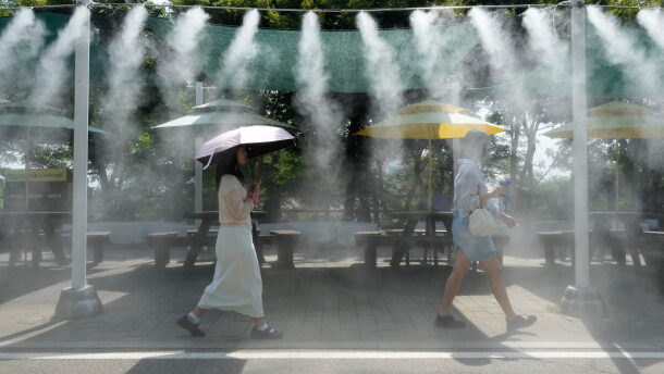 Visitors pass by the cooling fog device at Gwangmyeong Cave tourist site in Gwangmyeong, South Korea, Aug. 6, 2026.