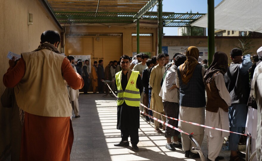 Lines of people snake through the courtyard of a food distribution center in Kabul in October.