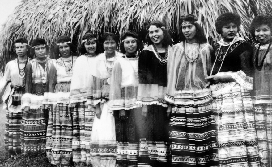 Seminole women wear patchwork skirts in an archival image.