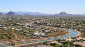 The Central Arizona Project canal winds through Phoenix on March 26, 2026. The 336-mile canal system pumps water from the Colorado River to the Phoenix and Tucson areas. Water supplies for the canal's users will be cut under a new plan for managing the Colorado River.