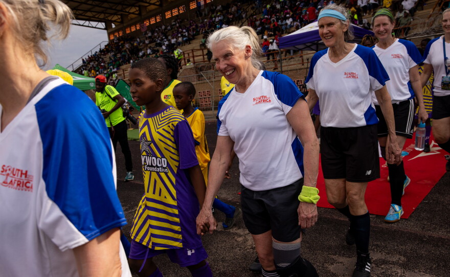 Pam Woodworth, Margot Rendall and Anne Snelling-Lee from the New England Breakers walk onto the field for their game against Togo's team Femme Foot. Youth from local soccer clubs held hands with players from each team as they made their way on to the field before each game.