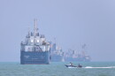 A small motorboat passes anchored vessels in the Strait of Hormuz off Bandar Abbas, Iran, Thursday, June 11, 2026.