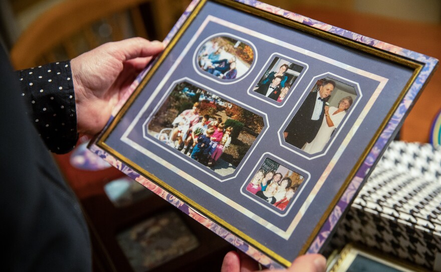 June Kelly holds a framed collection of photos of her mother, Marilyn Kelly.