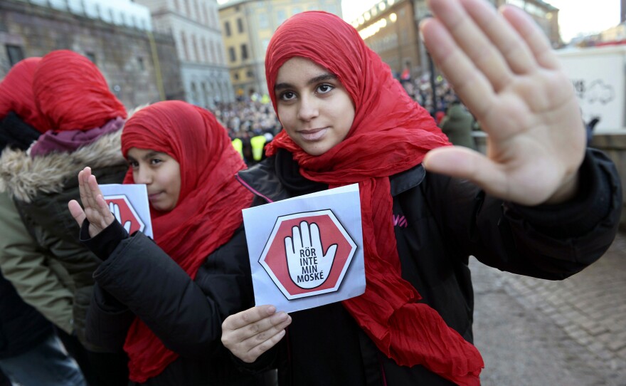 Two young girls carry leaflets reading "Don't touch my mosque" as they participate in a demonstration at the Parliament House in Stockholm last month.