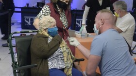 A woman receives a COVID-19 vaccine at the vaccination super station at Grossmont Center in La Mesa, Calif. Feb. 2, 2021.