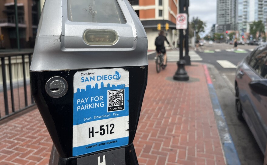 A man rides past a City of San Diego parking meter, Aug. 15, 2025.