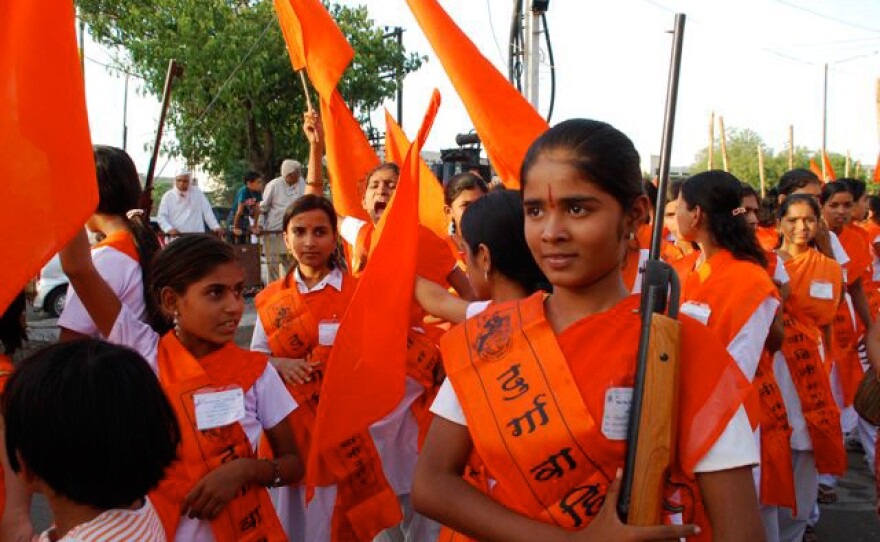 14-year-old Chinmayee poses with a rifle at the Durga Camp graduation ceremony.