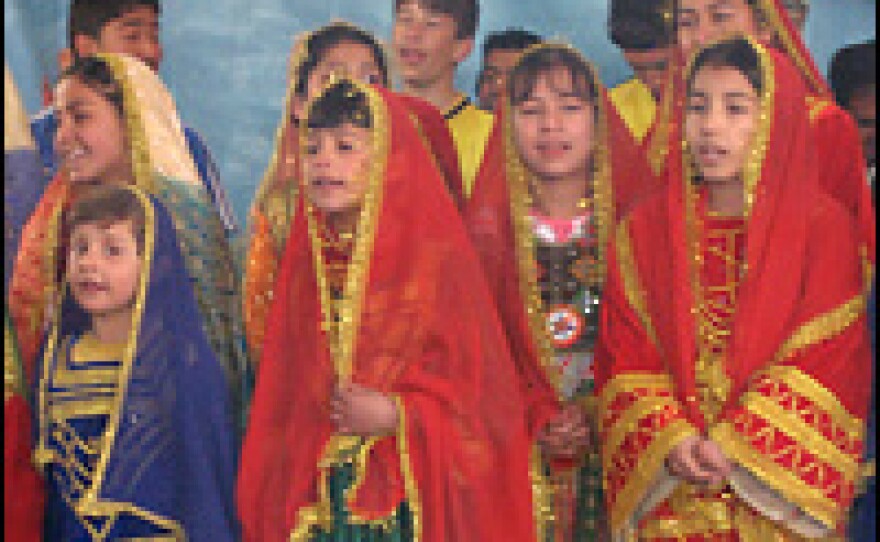 Girls dressed in traditional Afghan costumes sing during a circus performance.