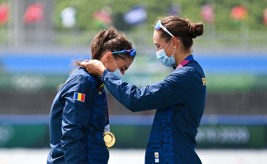 Gold medalists Romania's Ancuta Bodnar and Simona Radis celebrate on the podium following the women's double sculls final during the Tokyo 2020 Olympic Games at the Sea Forest Waterway in Tokyo on July 28, 2021.
