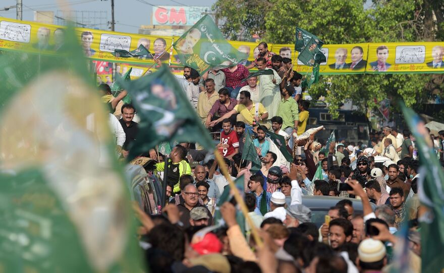 Supporters of ousted Pakistani Prime Minister Nawaz Sharif march toward Lahore's airport ahead of his arrival from London on Friday.